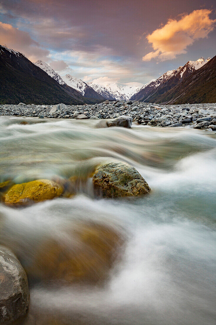 Mathias River at dusk, snow-covered peaks of Southern Alps beyond, Canterbury, New Zealand.
