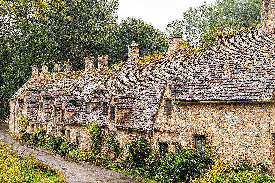The row of 14th Century cottages are Arlington Row in Bibury , Gloucestershire , England , Britain , Uk.
