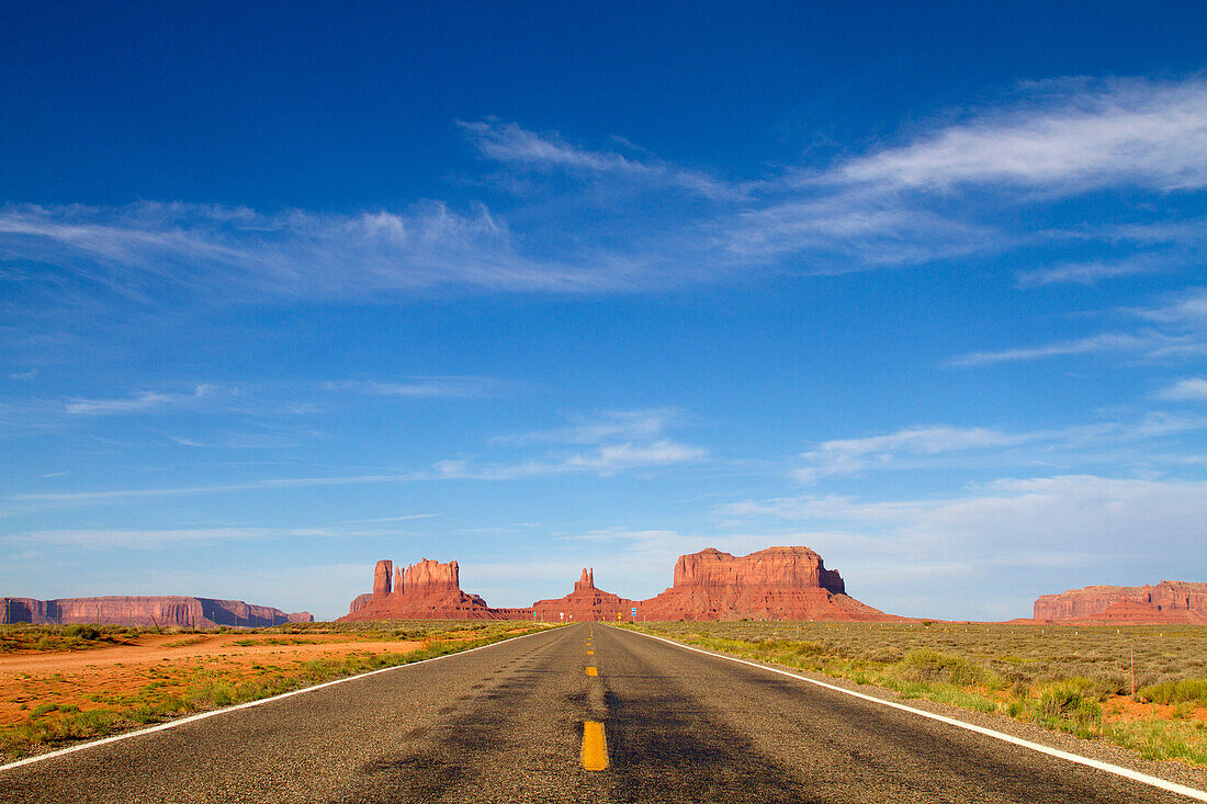 One of the most famous images of the Monument Valley is the long straight road (US 163)leading across flat desert towards sandstone buttes and pinnacles rock. Monument Valley Tribal Park, Nabajo Nation, Arizona/Utah, USA.
