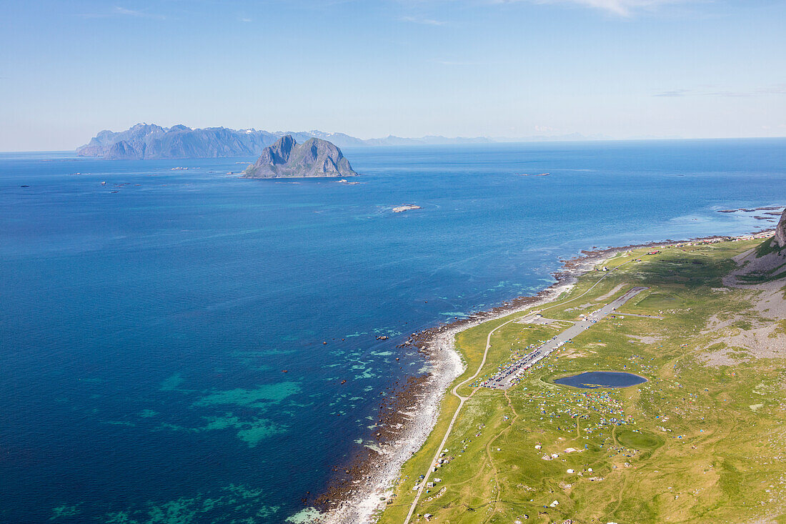 Tents in the green meadows surrounded by blue lake and sea, Vaeroy Island, Nordland county, Lofoten archipelago, Norway, Scandinavia, Europe