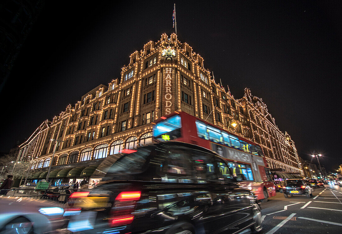 A London taxi and a London bus drive past Harrods, London, England, United Kingdom, Europe