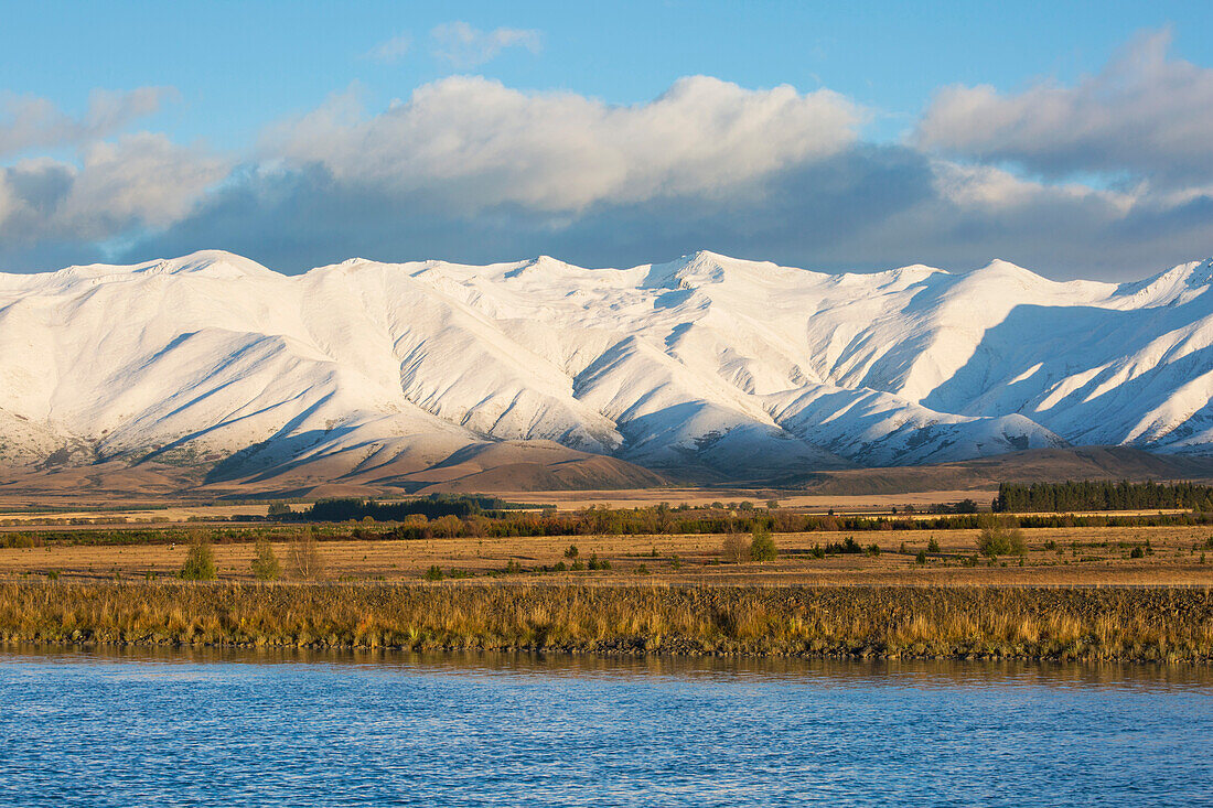 The Ben Ohau Range cloaked in autumn snow, the Pukaki Canal in foreground, Twizel, Mackenzie district, Canterbury, South Island, New Zealand, Pacific