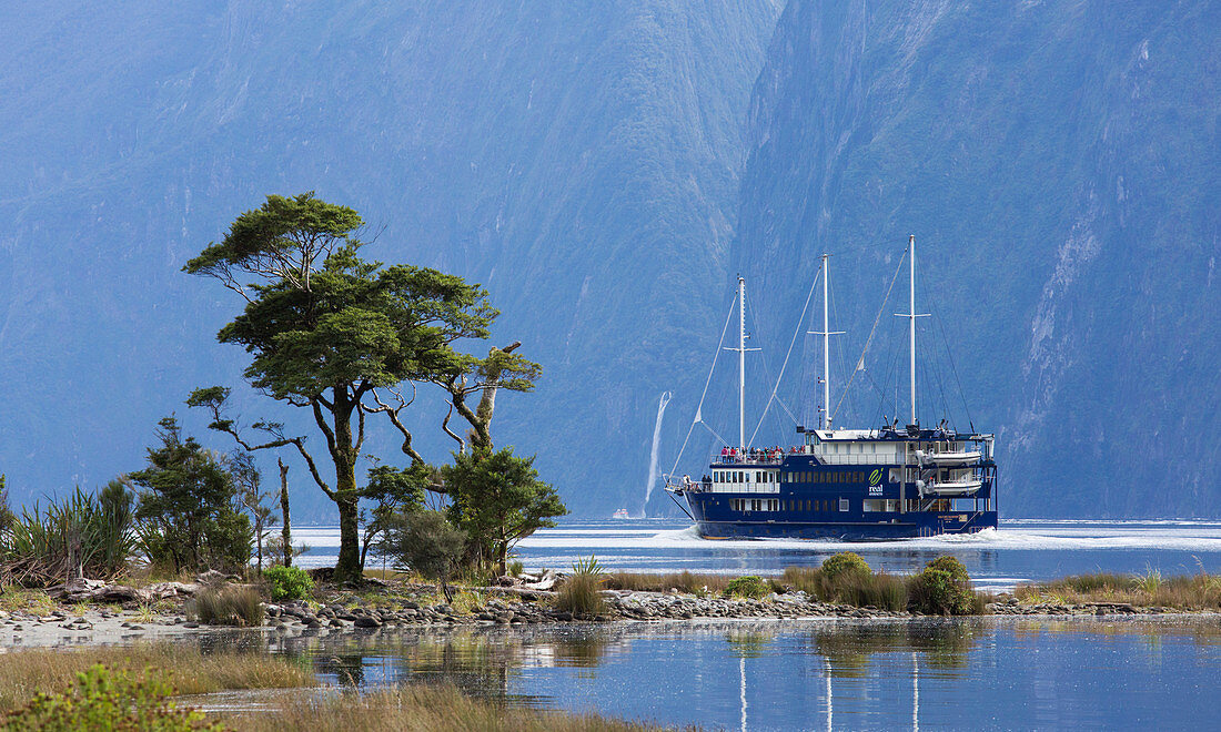 The Milford Mariner dwarfed by steep mountains, Milford Sound, Fiordland National Park, UNESCO World Heritage Site, Southland, South Island, New Zealand, Pacific
