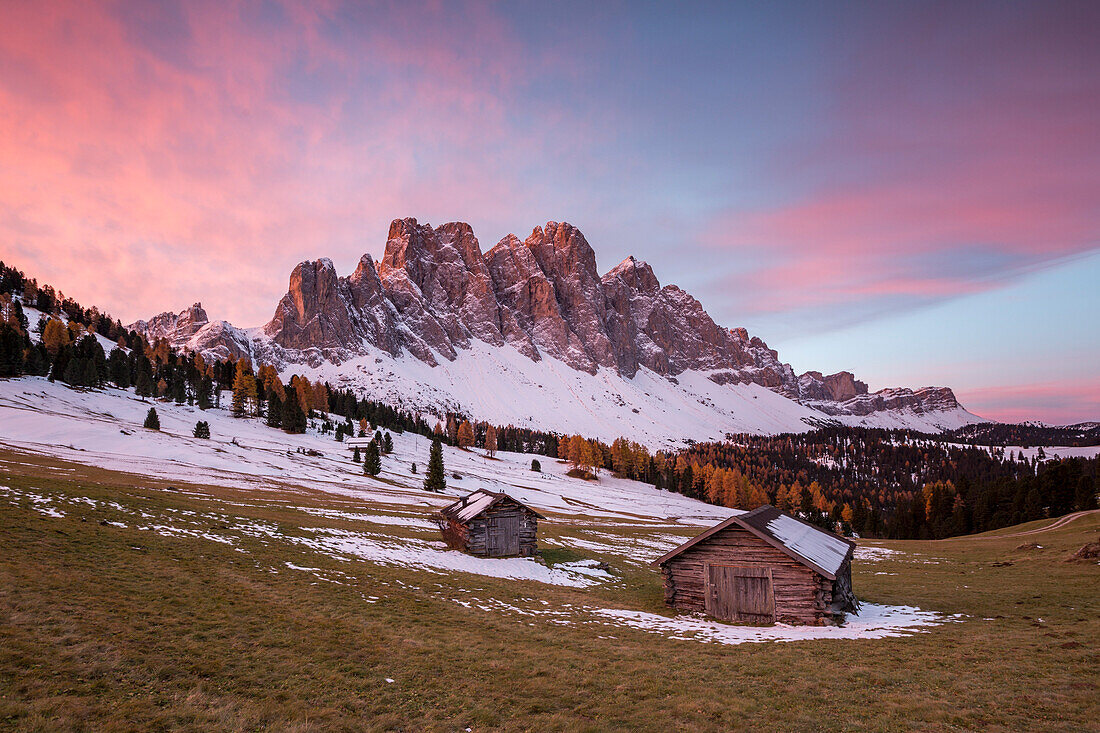 Sunrise with two wooden lodges and Odle Dolomites, Malga Gampen, Funes, Bolzano, Trentino Alto Adige , Sudtirol, Italy, Europe