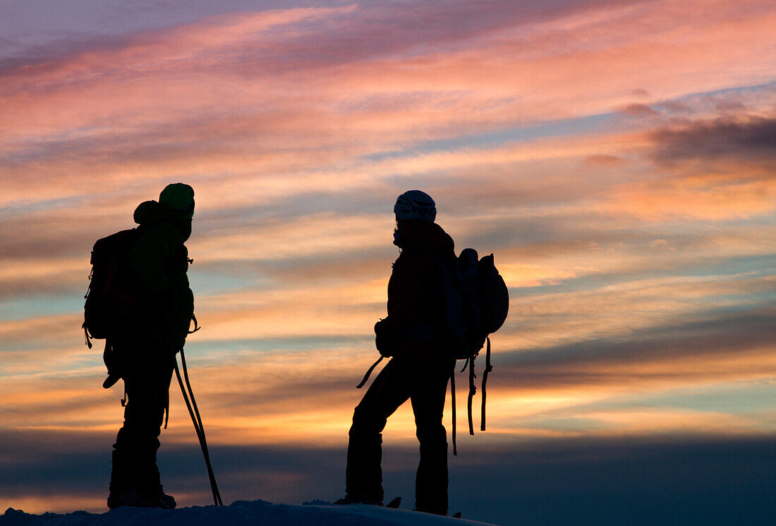 Europe, Italy, Lombardy, Two trekkers, in the sunset, after a journey spent on the mountains