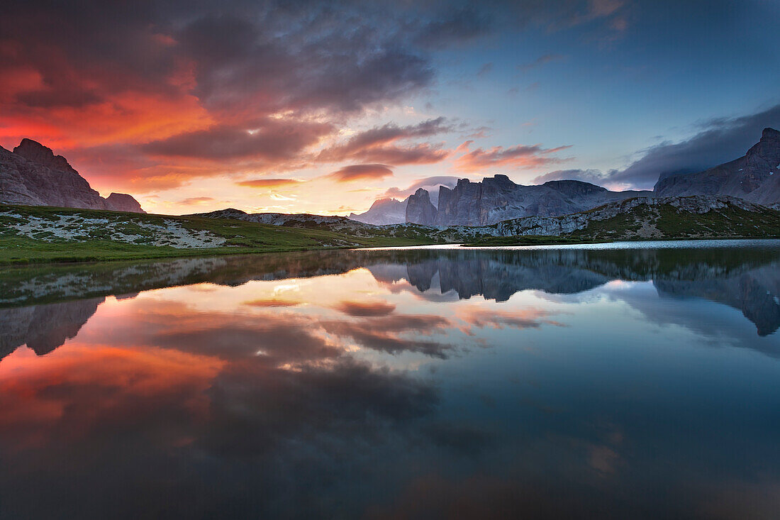 Dolomites, Italy, Clouds and colors at dawn are reflected at Laghi dei Piani, not far from Locatelli hut in Sesto Dolomites