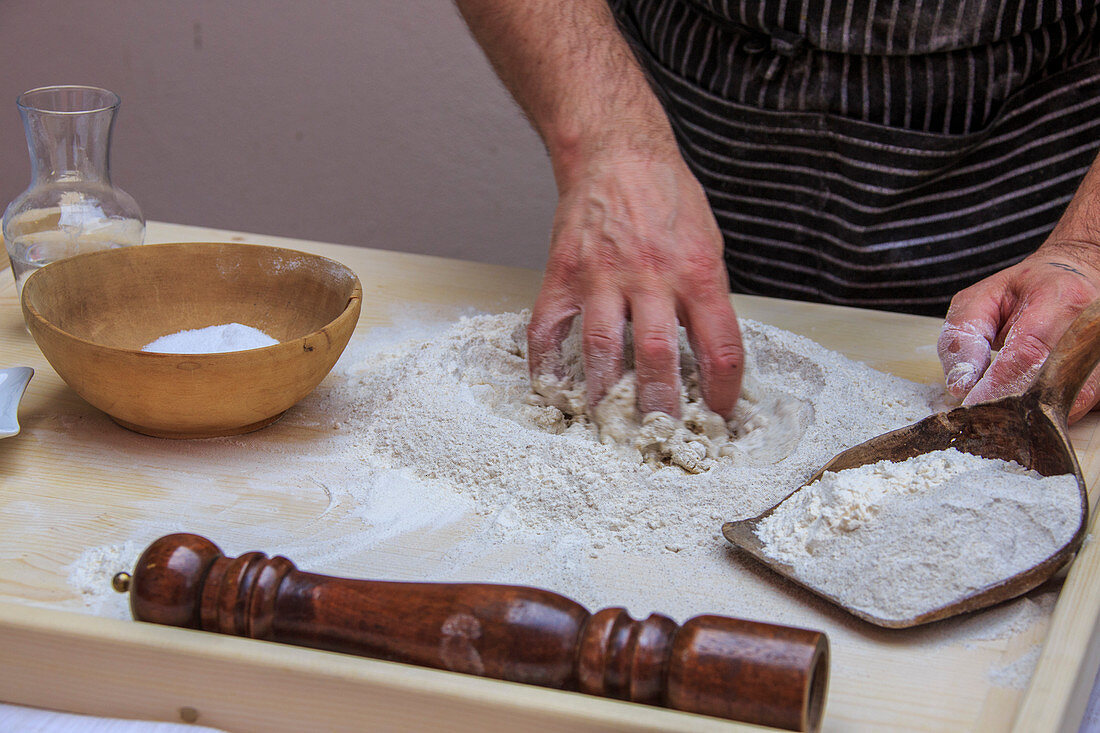 Cook knead flour and water to prepare Pizzoccheri, Lombardy, Italy, Europe
