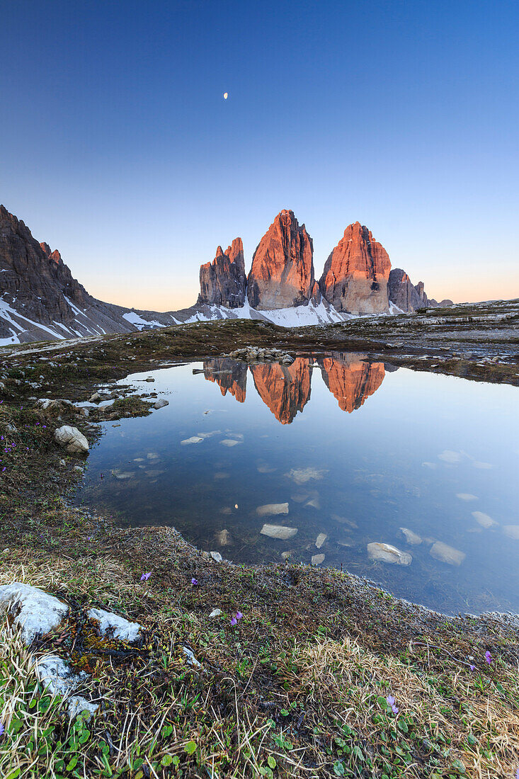 Dawn illuminates the Three Peaks of Lavaredo reflected in the lake, Sesto Dolomites Trentino Alto Adige Italy Europe