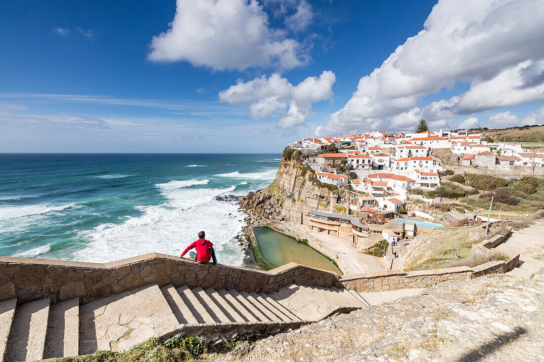 Tourist admires the perched village of Azenhas do Mar surrounded by the blue water of the Atlantic Ocean Sintra Portugal Europe