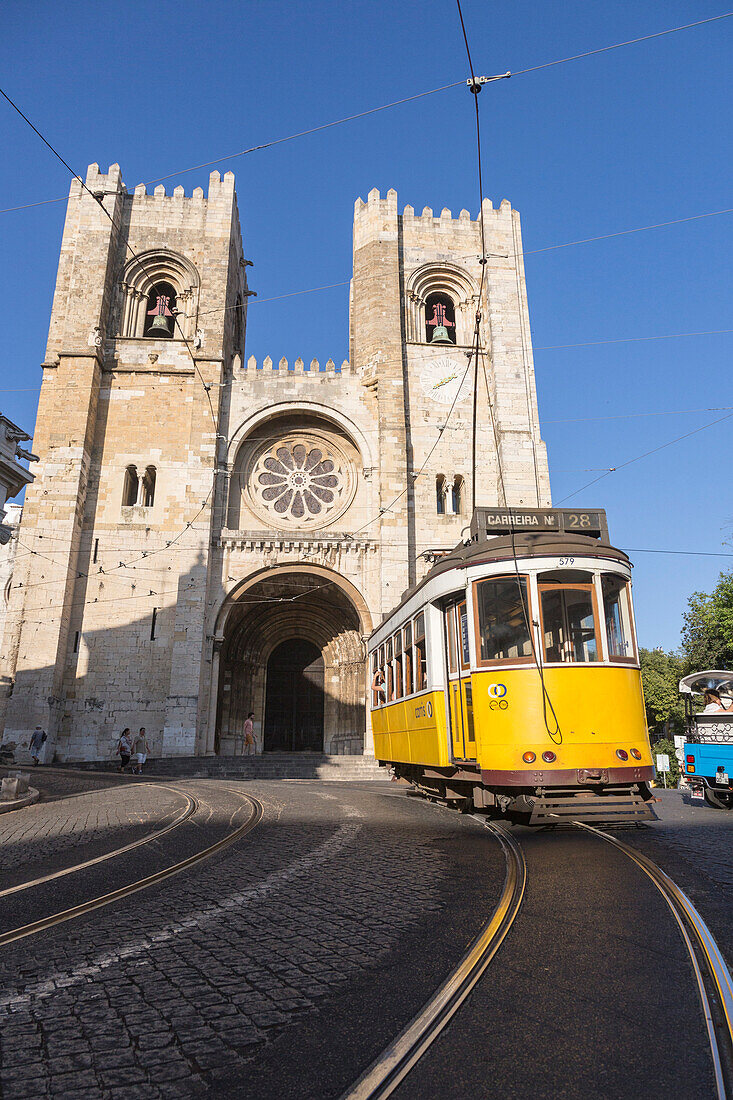 The yellow tram number 28 close to the ancient cathedral of Alfama district Lisbon Portugal Europe