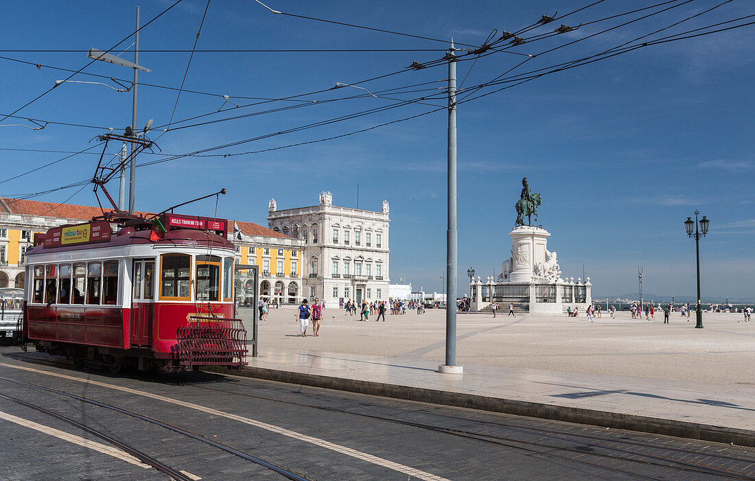 A typical red tram stops at the historical Praca Do Comercio square near the Tagus river Lisbon Estremadura Portugal Europe