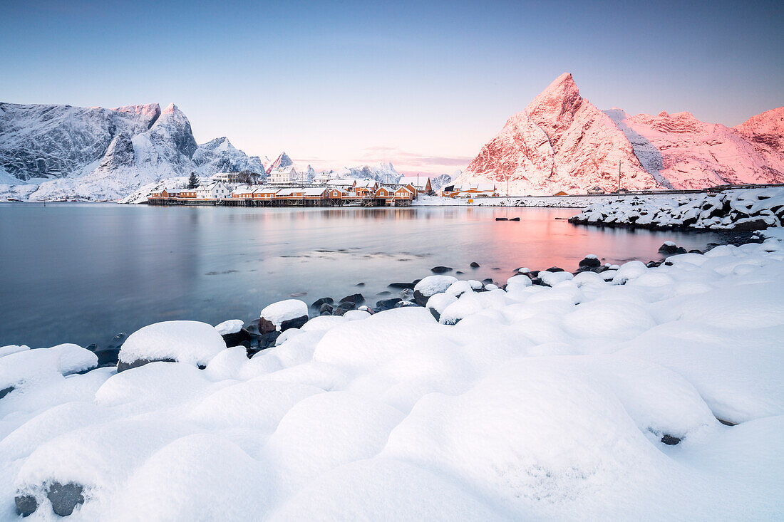 The colors of dawn frames the fishermen houses surrounded by snowy peaks Sakris+©y Reine Nordland Lofoten Islands Norway Europe