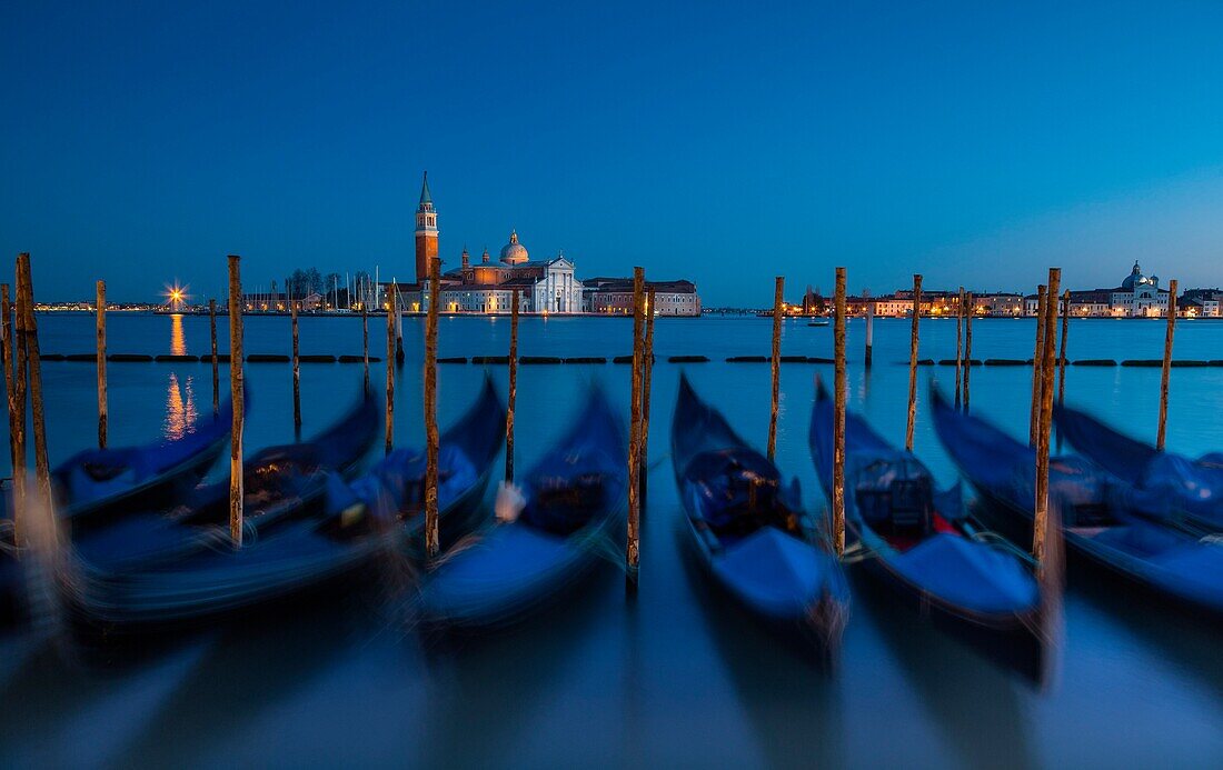 Venice, Veneto, Italy, View of San Giorgio cathedral during a quiet winter evening, with gondolas on the foreground