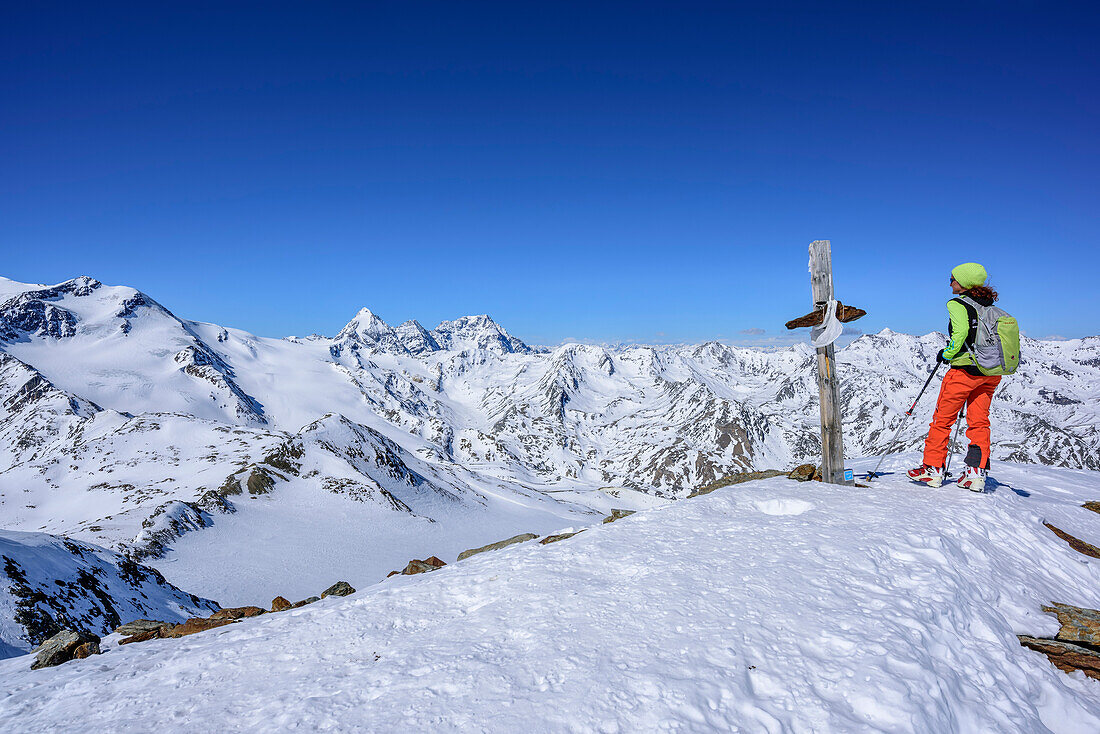 Woman backcountry skiing standing at Cima Marmotta, Zufallspitzen, Koenigsspitze, Zebru and Ortler in background, Cima Marmotta, valley Martelltal, Ortler range, Vinschgau, South Tyrol, Italy