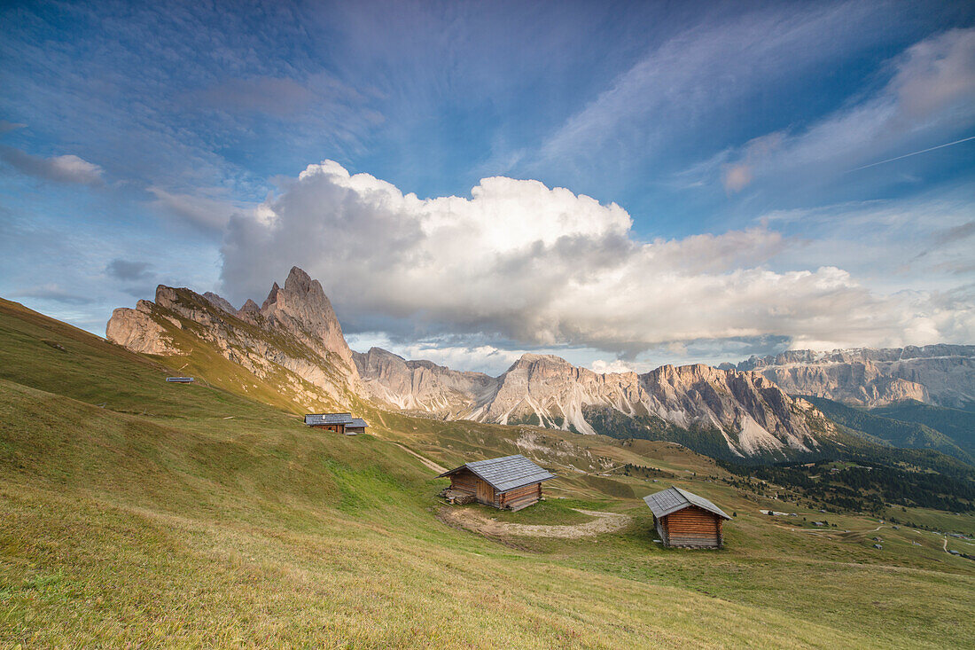 Sunset on the green meadows and huts of the Odle mountain range seen from Seceda, Val Gardena, Trentino-Alto Adige, Italy, Europe