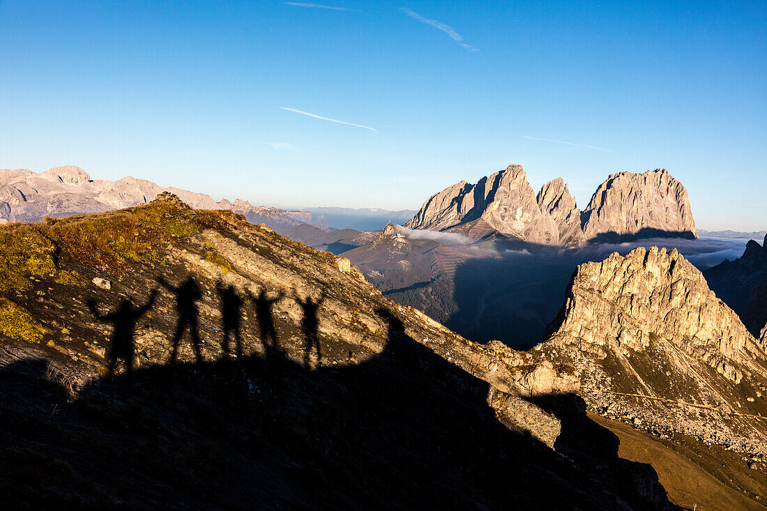 Silhouettes of hikers frame Sass Beca and Sassolungo from Cima Belvedere, Canazei, Val di Fassa, Trentino-Alto Adige, Italy, Europe