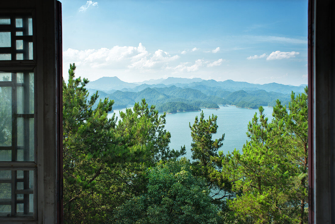 A view out the window on pine trees, the lake and mountain chains of Zhejiang province, China, Asia