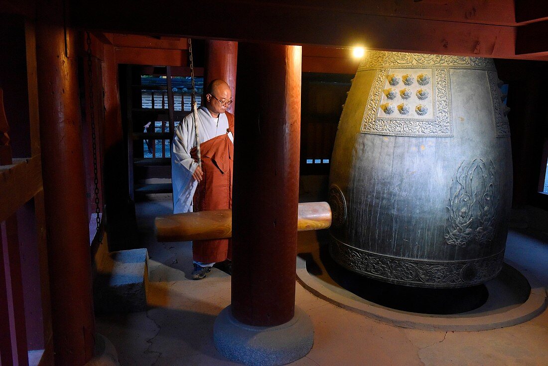 A monk calls the monks together by hitting a bell at Baekyangsa temple in Naejangsan National Park,South Korea.