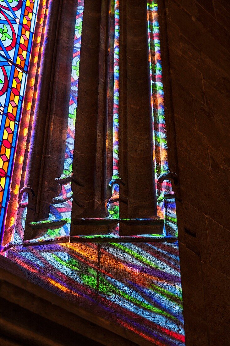 Light from a stained glass window on the side of the window. Building of the Lonja de la Seda (Silk Exchange). Valencia, Spain