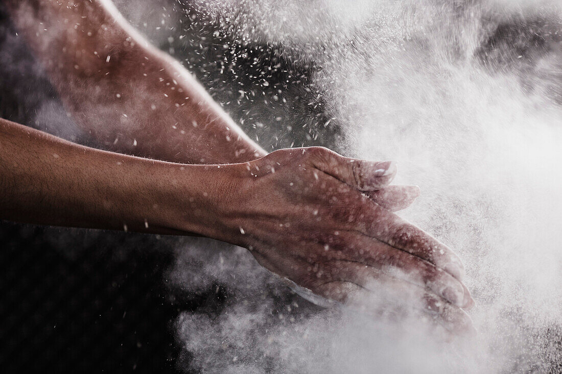 Cropped image of woman's hand dusting chalk powder for exercising