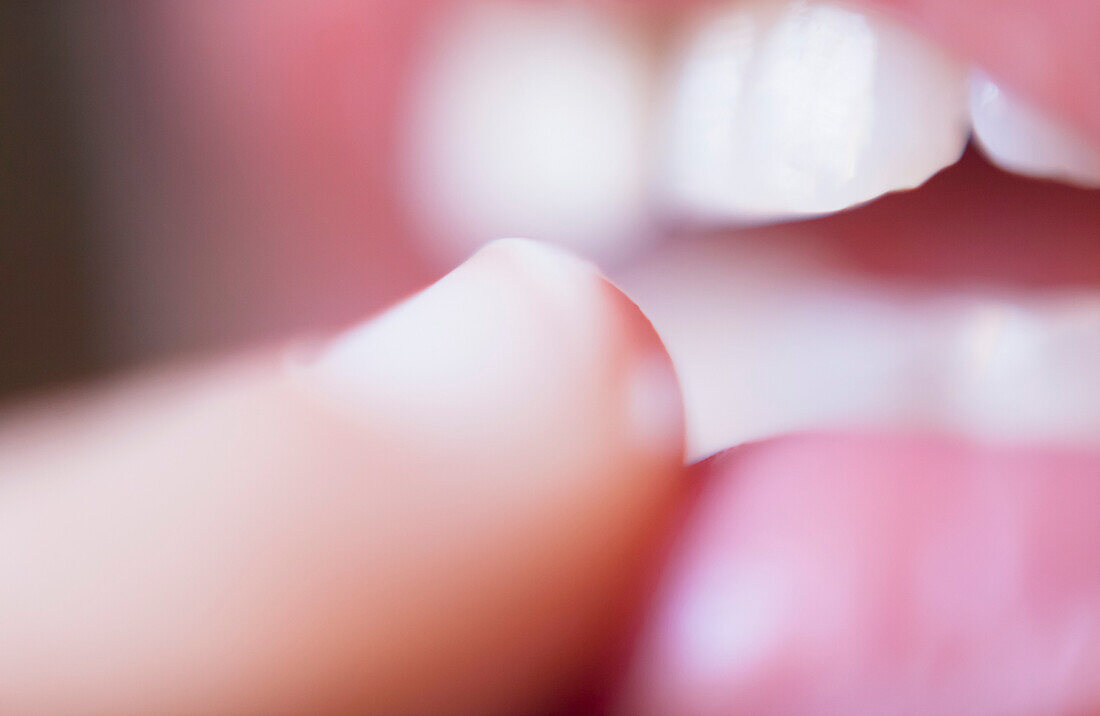 Extreme close-up of finger touching lips