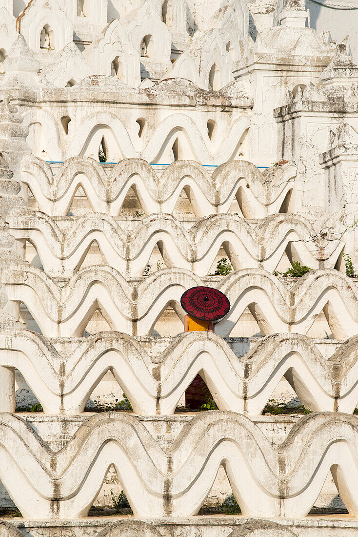 Mingun, Sagaing region, Myanmar Burma , Woman with red umbrella in the middle of the white terraces of the Hsinbyume white pagoda