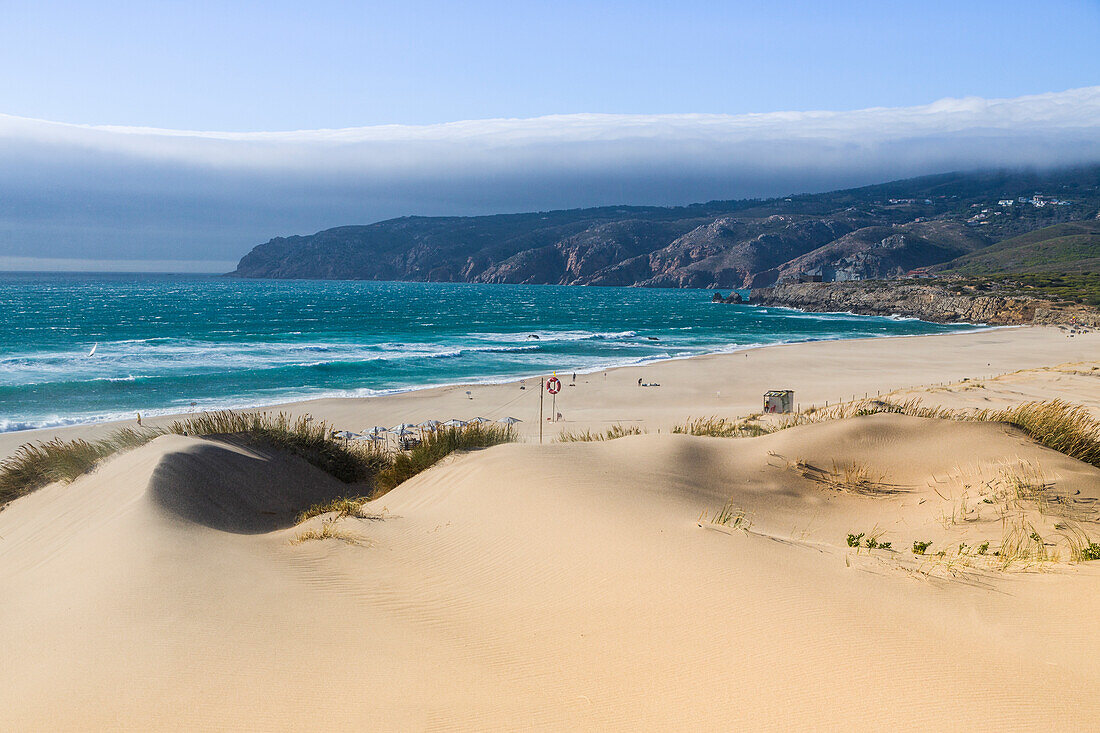 Sandy dunes lead to the long beach of Cascais surrounded by the blue ocean Estoril Coast Lisbon Portugal Europe