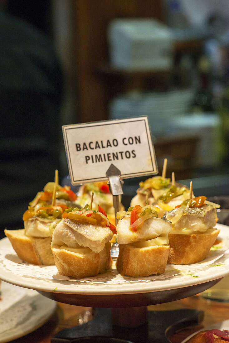 Bacalao con pimientos (codfish with peppers). Typical Pintxos, also called tapas at popular San Sebastian bar, Basque Country, Spain.