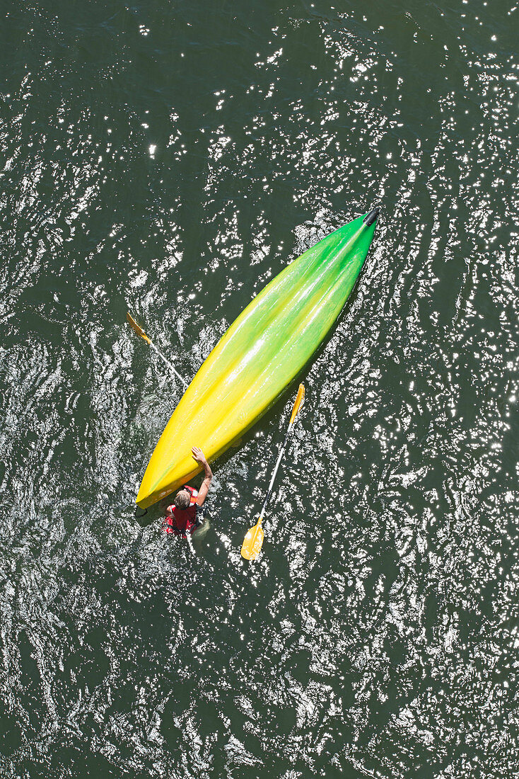 Directly above shot of man with upside down kayak in water