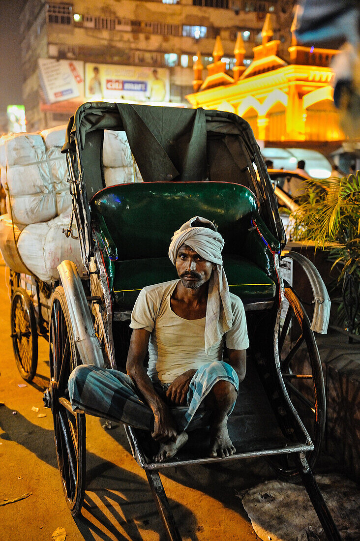 India, Kolkata, man waiting in a rickshaw