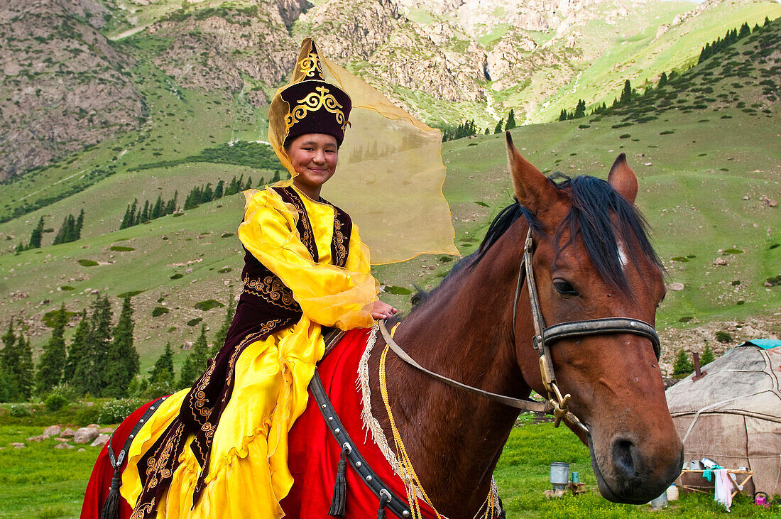 Kyrgyzstan, Issyk Kul Province (Ysyk-Kol), Juuku valley, Goulzana Talantbekoze wears the traditionel Kiz Kumai clothes, a horse game where the man tries to catch a girl on horseback and kiss her