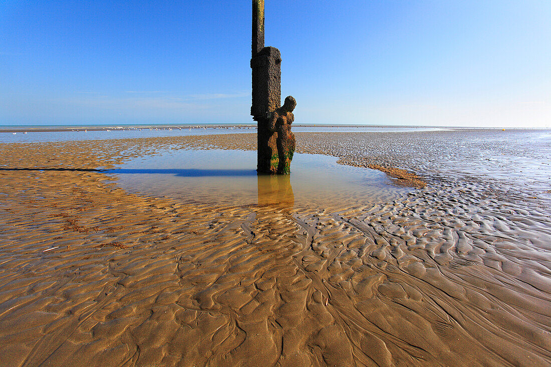 Belgium, Oostduinkerke, Bizarre statue on the beach at low tide.