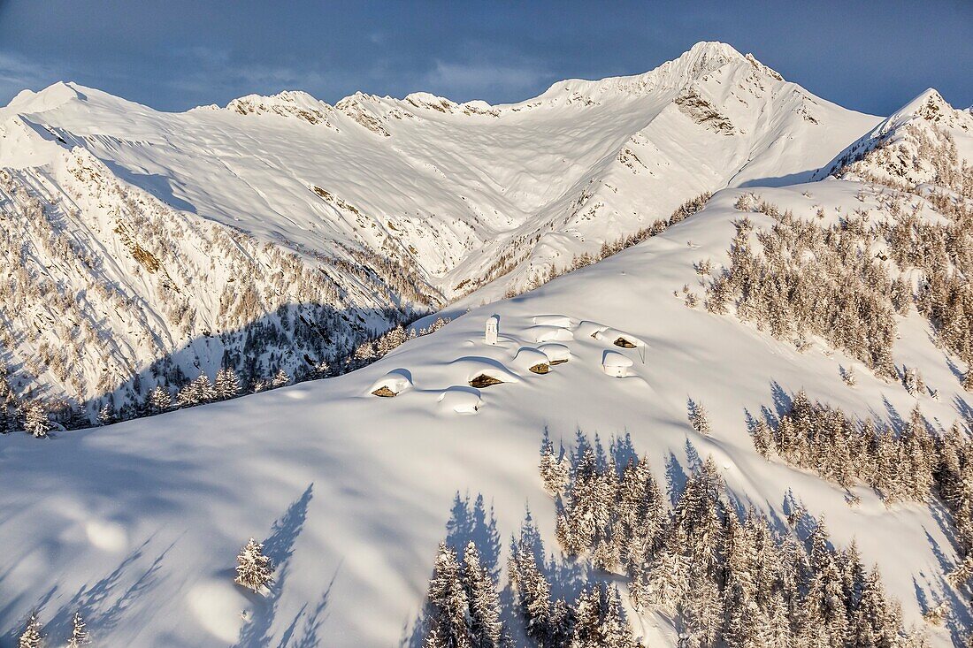 Italy, Italian Alps, Lombardy, The huts and the bell tower of Alpe Cima sorrounded by metres of snow