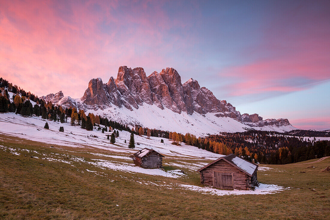 Sunrise with two wooden lodges and Odle Dolomites, Malga Gampen, Funes, Bolzano, Trentino Alto Adige - Sudtirol, Italy, Europe