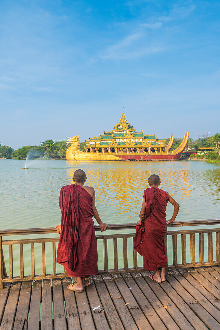 Yangon, Myanmar Burma , Two monks watching the Karaweik Palace on the Kandawgyi Lake