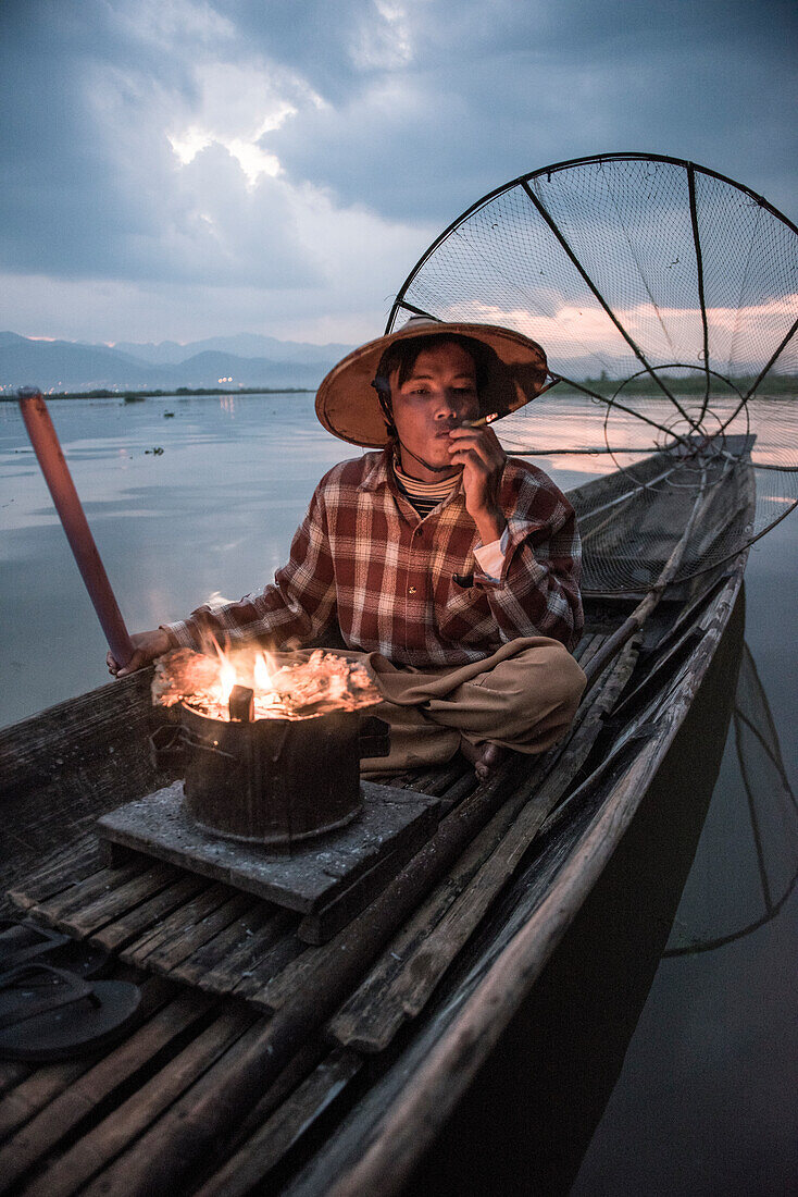Inle lake, Nyaungshwe township, Taunggyi district, Myanmar Burma , Local fisherman before dawn with fireplace on the boat
