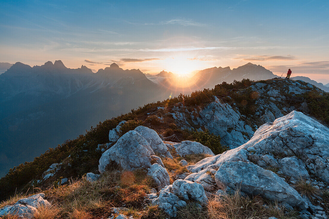 Europe, Italy, Veneto, Belluno, Hiker is looking at the rising sun fron the top of mount Celo, Dolomites, Agordino valley