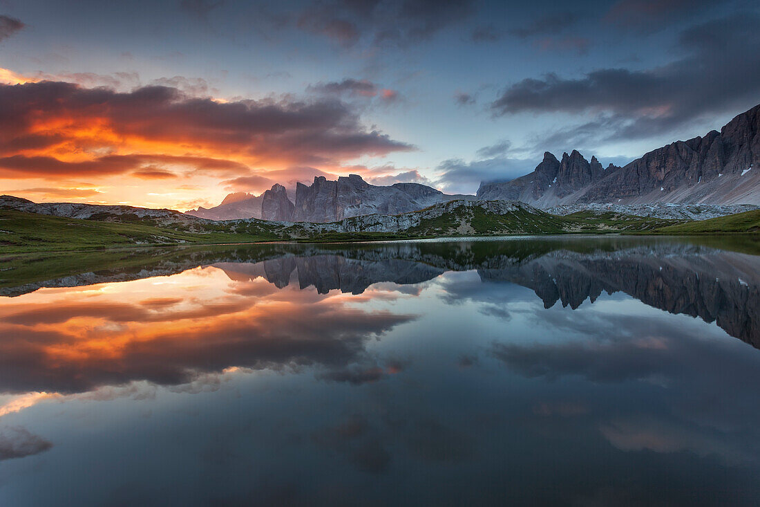 Dolomites, Italy, Clouds and colors at dawn are reflected at Laghi dei Piani, not far from Locatelli hut in Sesto Dolomites