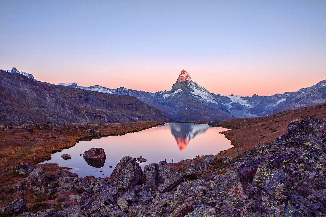 Hikers admire the Matterhorn reflected in the Stellisee at sunrise, Zermatt Canton of Valais Pennine Alps Switzerland Europe