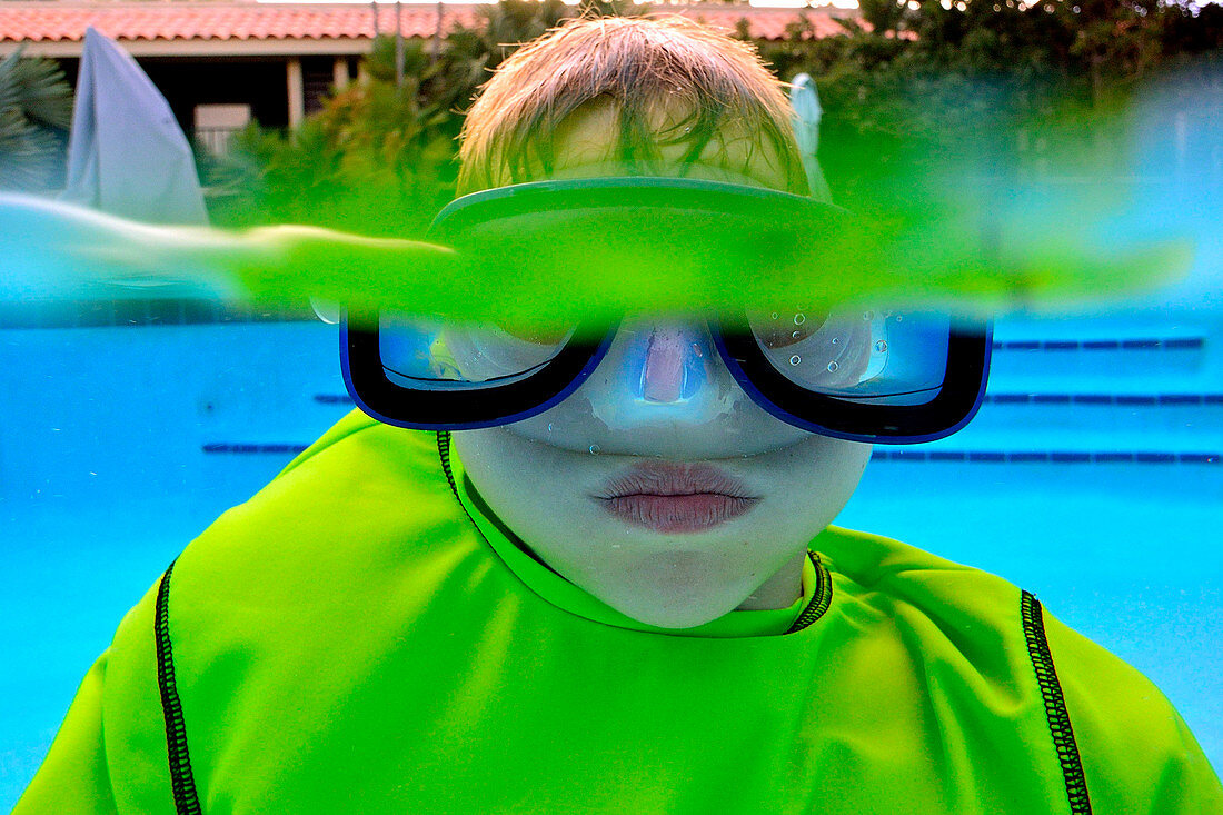 Boy Swimming Underwater In Swimming Pool