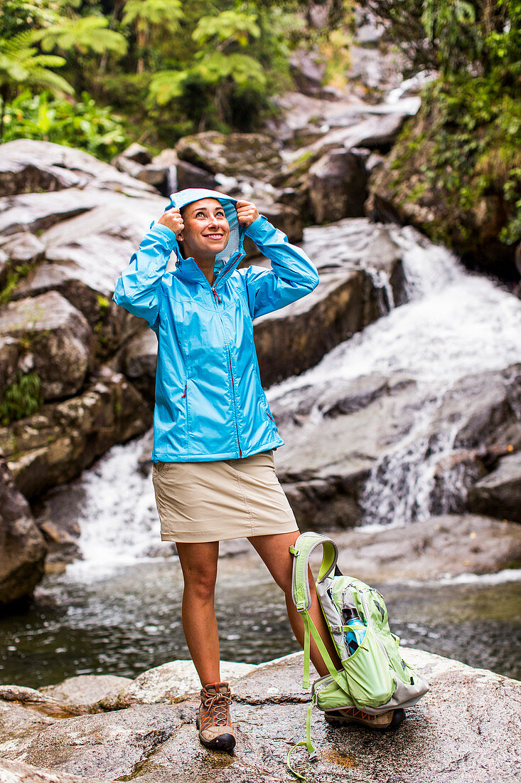 Portrait Of A Woman Wearing Jacket In Front Of A Waterfall And Creek
