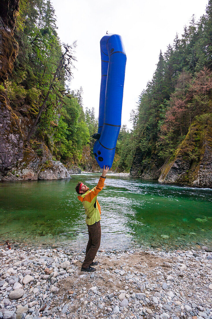 Explorer Evan Howard Balances His Packraft Above His Head