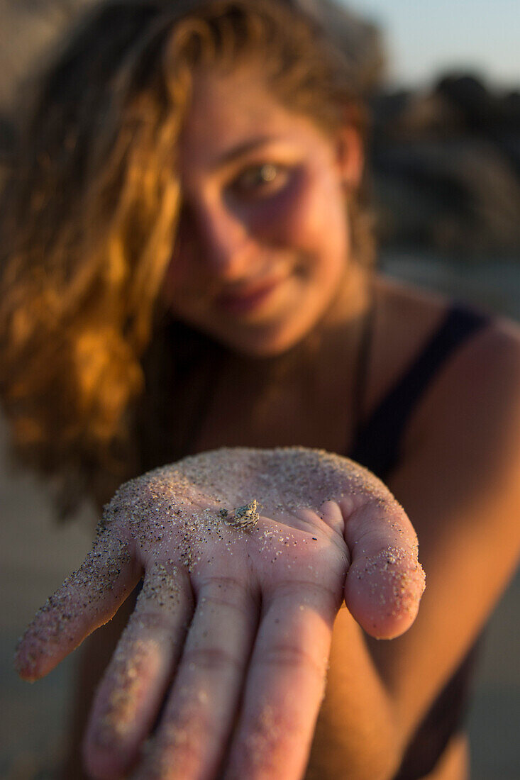 Woman In The Beach Showing Small Crab On Sand Covered Hand