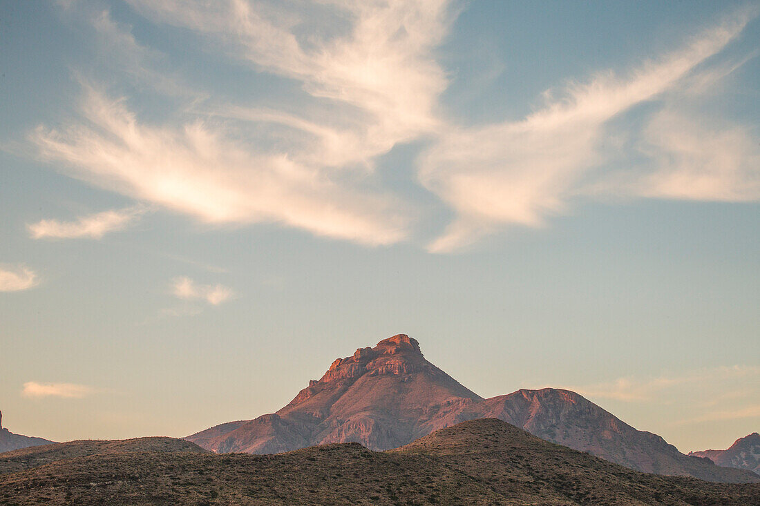 Mountain Range In The Distance Under A Softly Glowing Dawn Sky