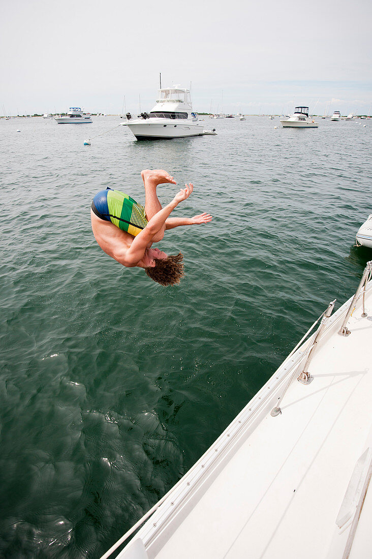 A Man Jumping Into The Water Of Great Salt Pond In New Harbor Of Block Island