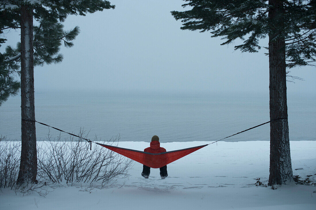 Person Relaxing On Hammock Enjoying A Winter Storm On The South Shore Of Lake Tahoe