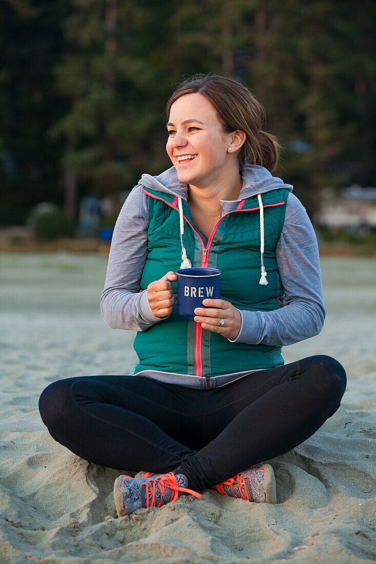 Portrait Of A Smiling Woman Enjoying Hot Drink At A Beach