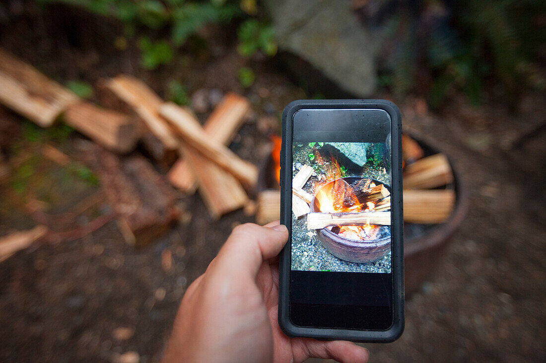 A Camper Taking A Picture Of Campfire In A Mobilephone
