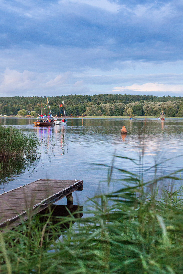 zum jährlichen Güstrower Inselseefest werden die Boote mit bunten Lampions geschmückt und kreuzen in der Dämmerung auf dem Inselsee, Bootssteg, Holzsteg, Segelboot, Mecklenburgische Schweiz, Mecklenburgische Seen, Mecklenburgisches Seenland, Güstrow, Meck