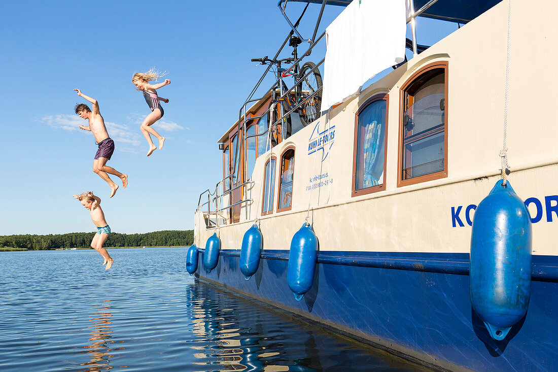 Family jumps from a boat into the water, swimming fun with a family, houseboat tour, Lake Mirower See, Kuhnle-Tours, Mecklenburg lakes, Mecklenburg lake district, MR, Mirow, Mecklenburg-West Pomerania, Germany, Europe